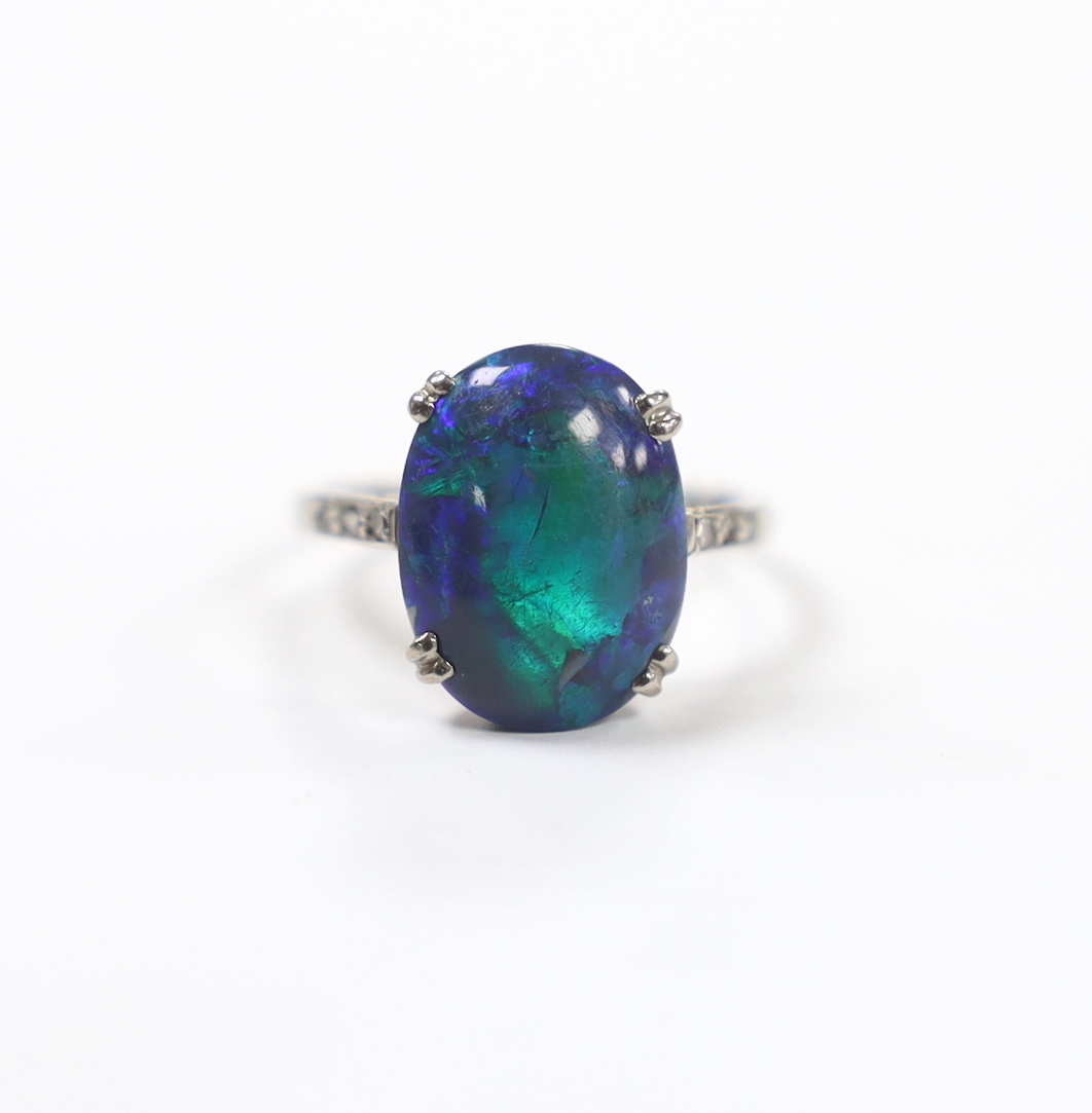 An 18ct, plat and single stone cabochon black opal set ring, with six stone diamond chip set shoulders, size K, gross weight 2.6 grams.
